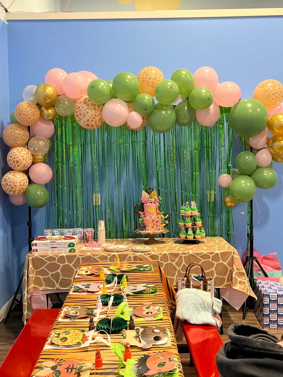 Jungle themed birthday party setup with balloon arch