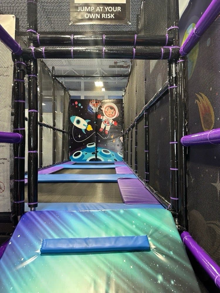 Space-themed trampoline area with astronaut mural at Sheffield Village